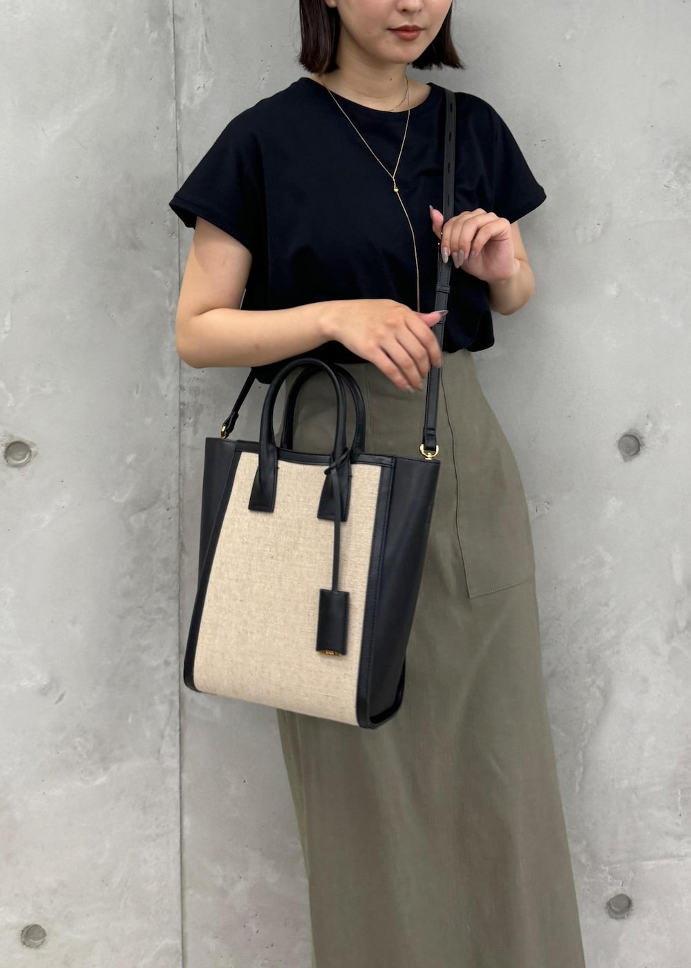 ブラック系のサンダル、グリーン系のスカート、ブラック系のTシャツ/カットソーを着用したレディースの夏コーディネートの10枚目の写真