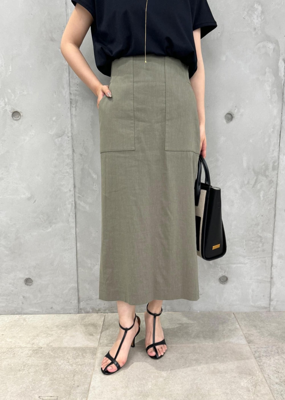 ブラック系のサンダル、グリーン系のスカート、ブラック系のTシャツ/カットソーを着用したレディースの夏コーディネートの7枚目の写真