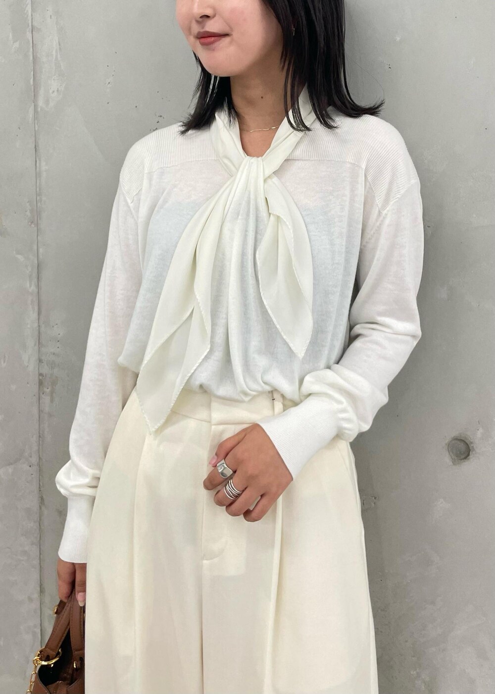 ブラウン系のハンドバッグ、ホワイト系のその他パンツ、ブラウン系のブーツを着用したレディースの秋コーディネートの4枚目の写真