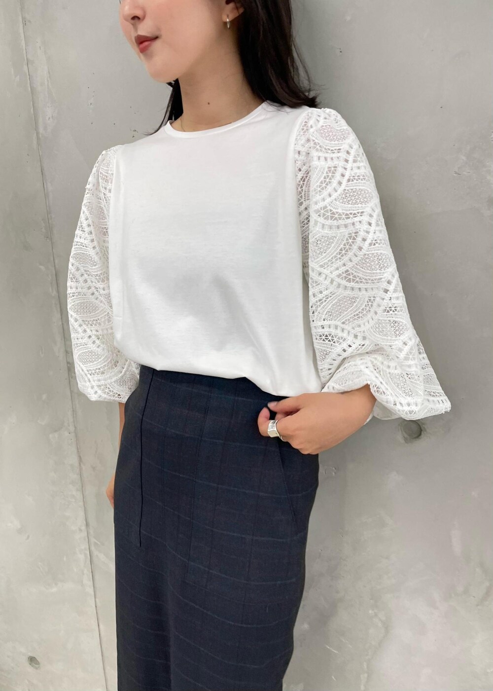 ブラック系のパンプス、グレー系のトートバッグ、ブルー系のスカートを着用したレディースの秋コーディネートの6枚目の写真