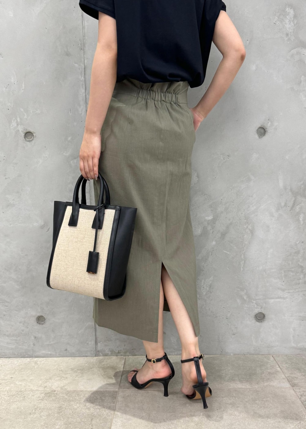 ブラック系のサンダル、グリーン系のスカート、ブラック系のTシャツ/カットソーを着用したレディースの夏コーディネートの8枚目の写真