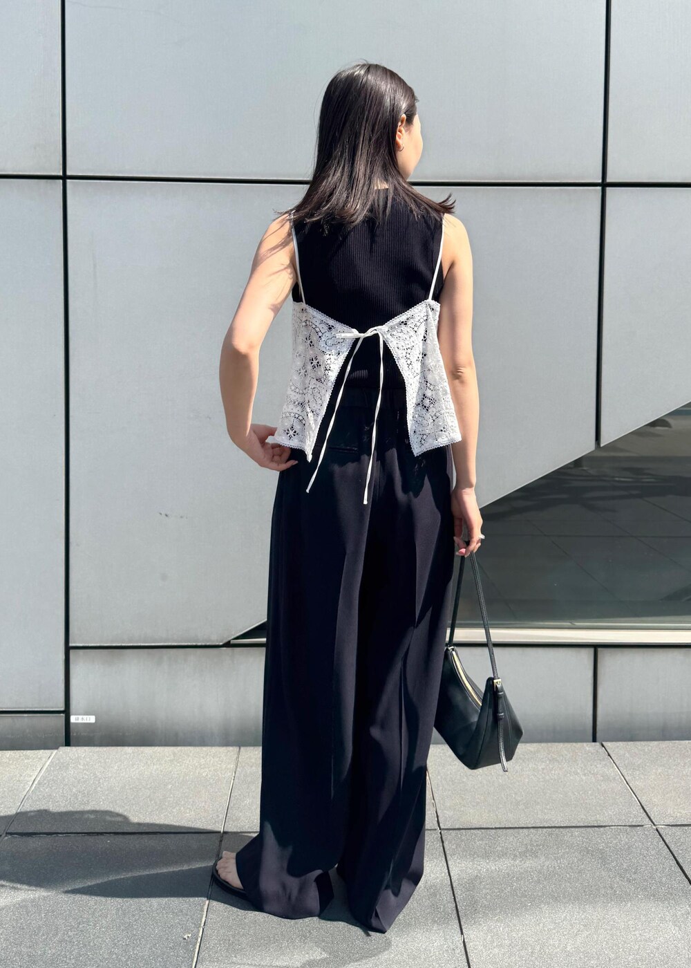 シルバー系のサンダル、ホワイト系のキャミソール、ブルー系のニット/セーターを着用したレディースの春コーディネートの3枚目の写真