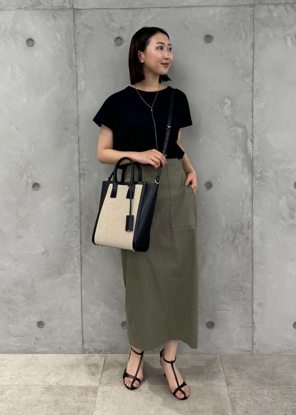 ブラック系のサンダル、グリーン系のスカート、ブラック系のTシャツ/カットソーを着用したレディースの夏コーディネートの5枚目の写真