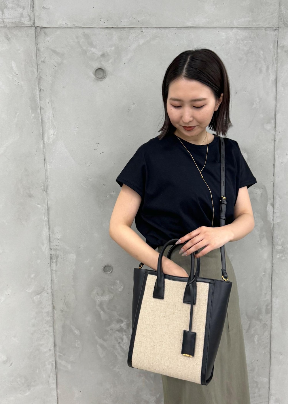 ブラック系のサンダル、グリーン系のスカート、ブラック系のTシャツ/カットソーを着用したレディースの夏コーディネートの9枚目の写真