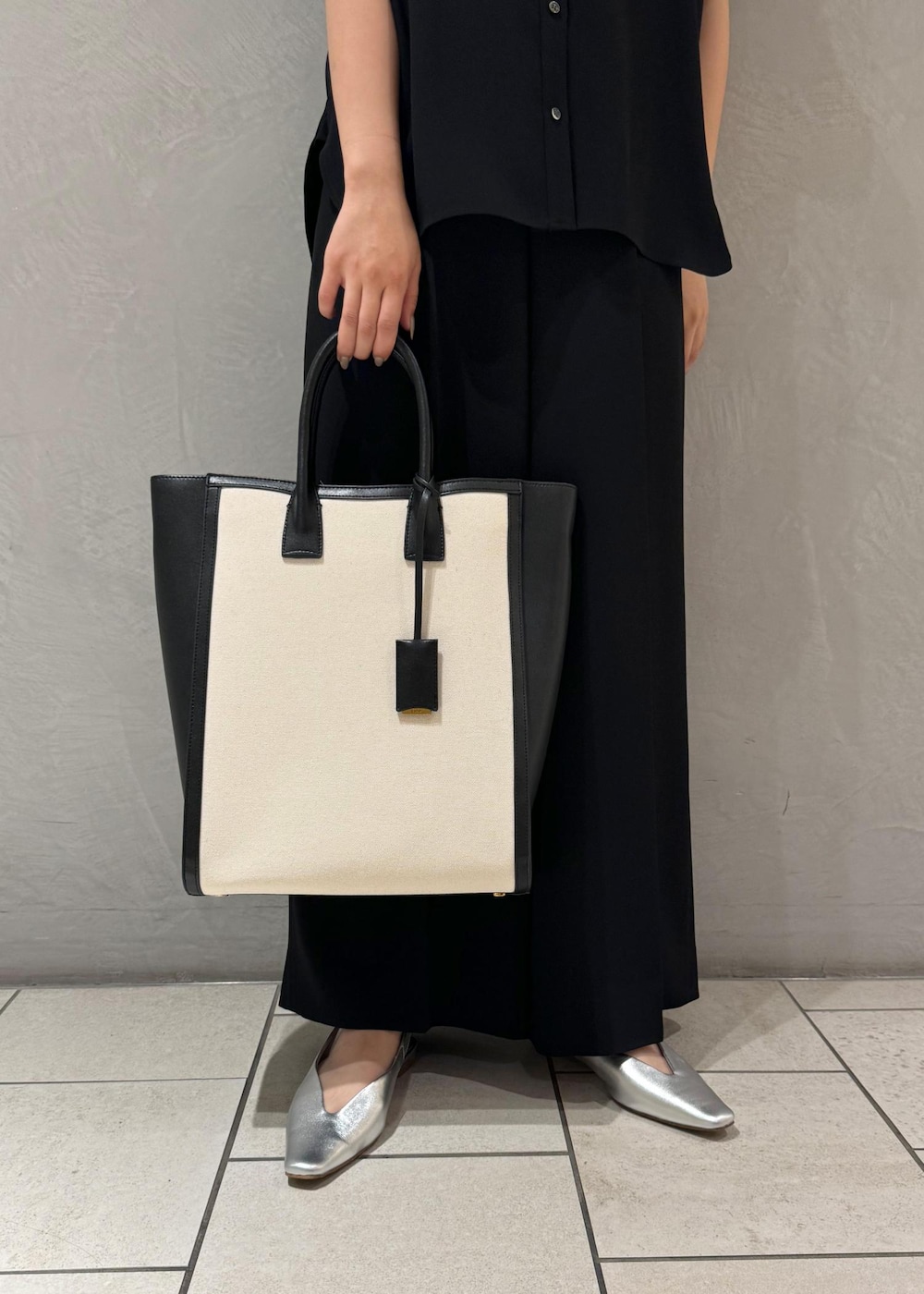 ブラック系のトートバッグ、シルバー系のパンプス、ブラック系のシャツ/ブラウスを着用したレディースの春コーディネートの10枚目の写真