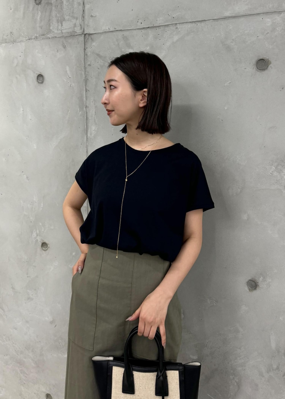 ブラック系のサンダル、グリーン系のスカート、ブラック系のTシャツ/カットソーを着用したレディースの夏コーディネートの6枚目の写真