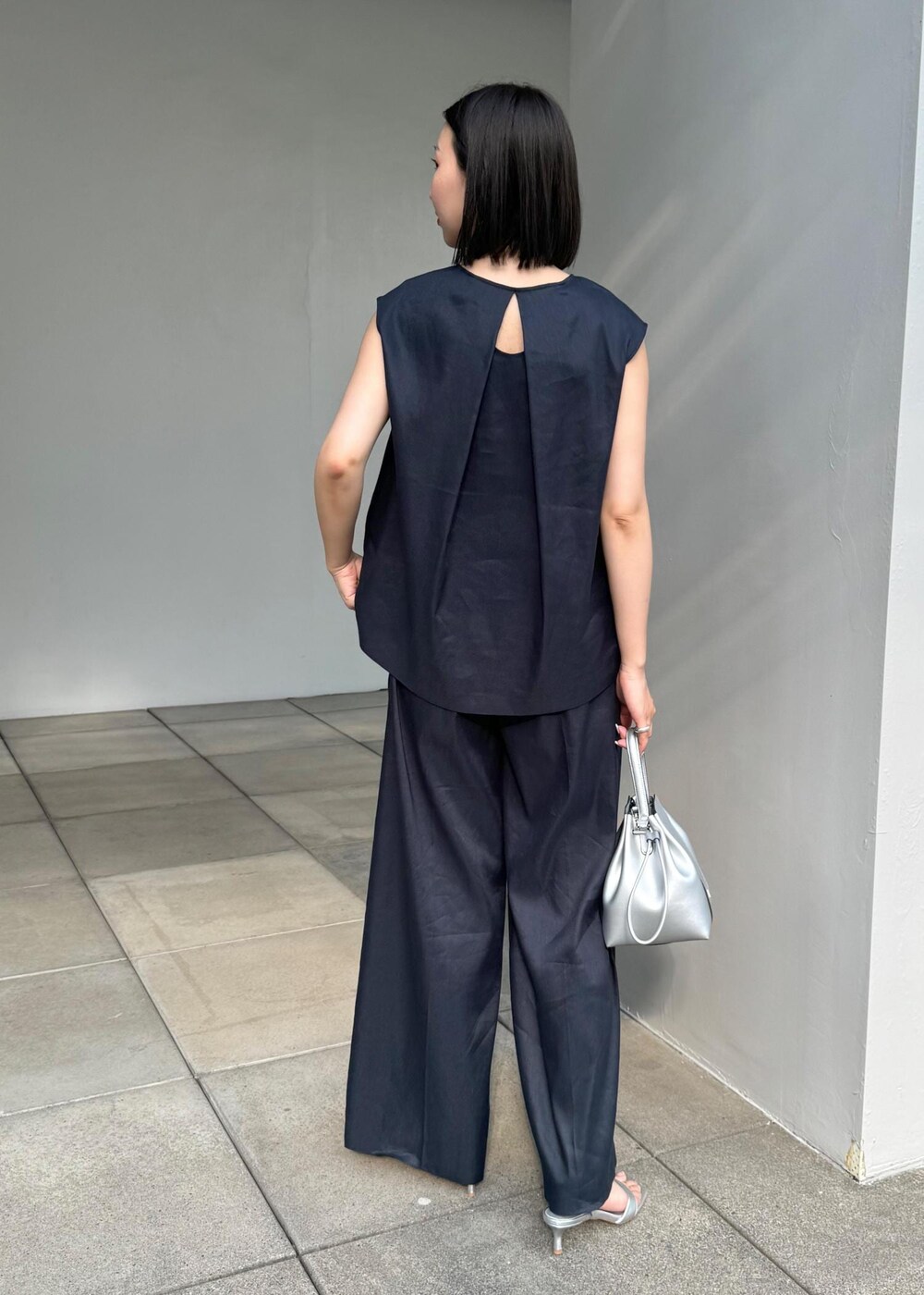 シルバー系のサンダル、シルバー系のハンドバッグ、ブルー系のシャツ/ブラウスを着用したレディースの夏コーディネートの3枚目の写真