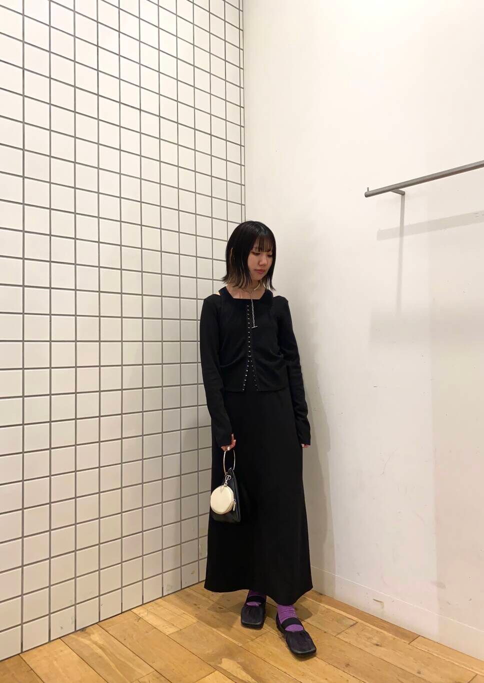 ブラック系のハンドバッグ、ブラック系のパンプス、ブラック系のワンピースを着用したレディースの春コーディネートの2枚目の写真