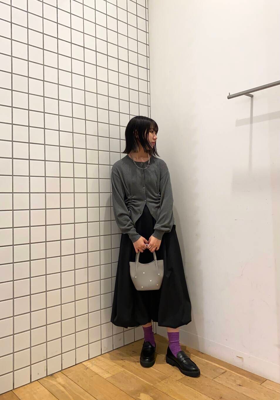 ブラック系のローファー、ブラック系のスカート、グレー系のショルダーバッグを着用したレディースの春コーディネートの2枚目の写真