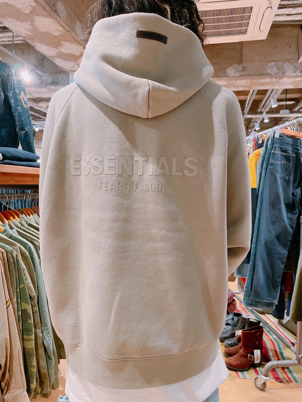 グリーン系のパーカー、ブルー系のデニムパンツ、ホワイト系のスニーカーを着用したメンズの春コーディネートの2枚目の写真