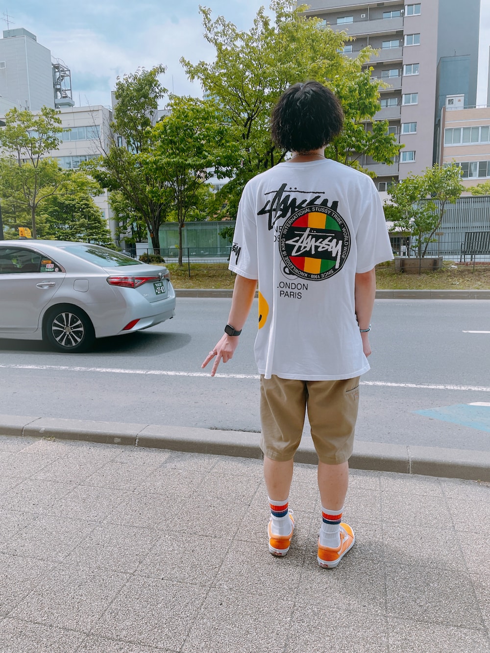 ホワイト系のTシャツ/カットソー、ベージュ系のチノパンツ、オレンジ系のスニーカーを着用したメンズの春コーディネートの2枚目の写真