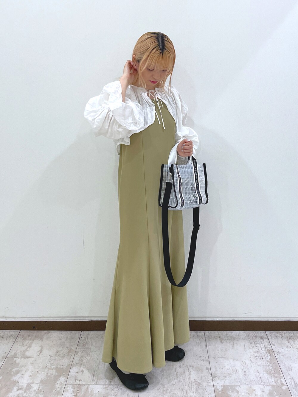 ホワイト系のカーディガン/ボレロ、グリーン系のワンピース、ブラック系のショルダーバッグを着用したレディースの春コーディネートの2枚目の写真