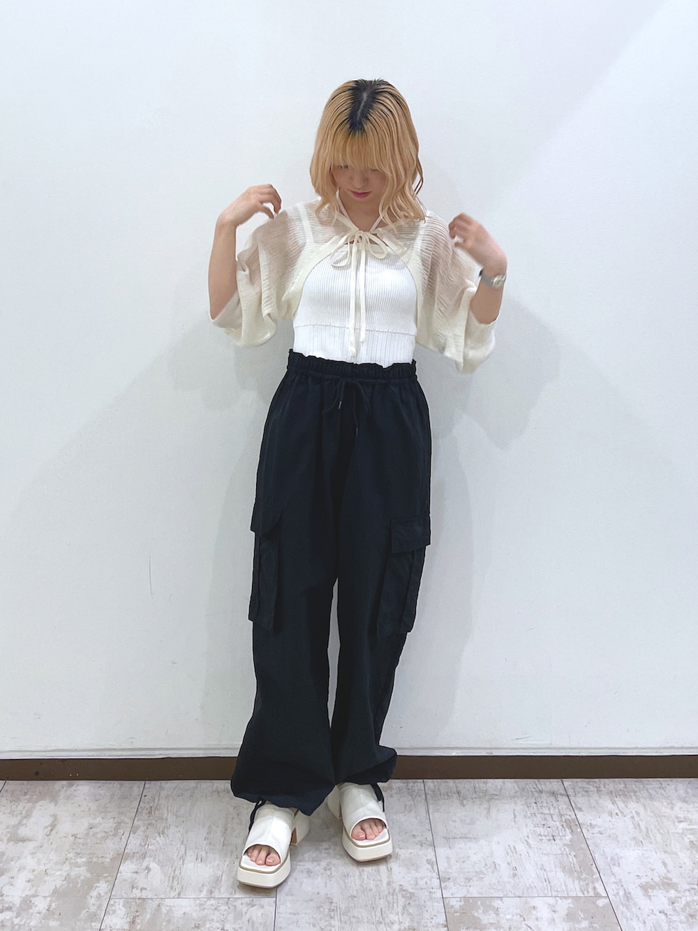 ホワイト系のカーディガン/ボレロ、ブラック系のカーゴパンツ、ホワイト系のサンダルを着用したレディースの夏コーディネートの2枚目の写真