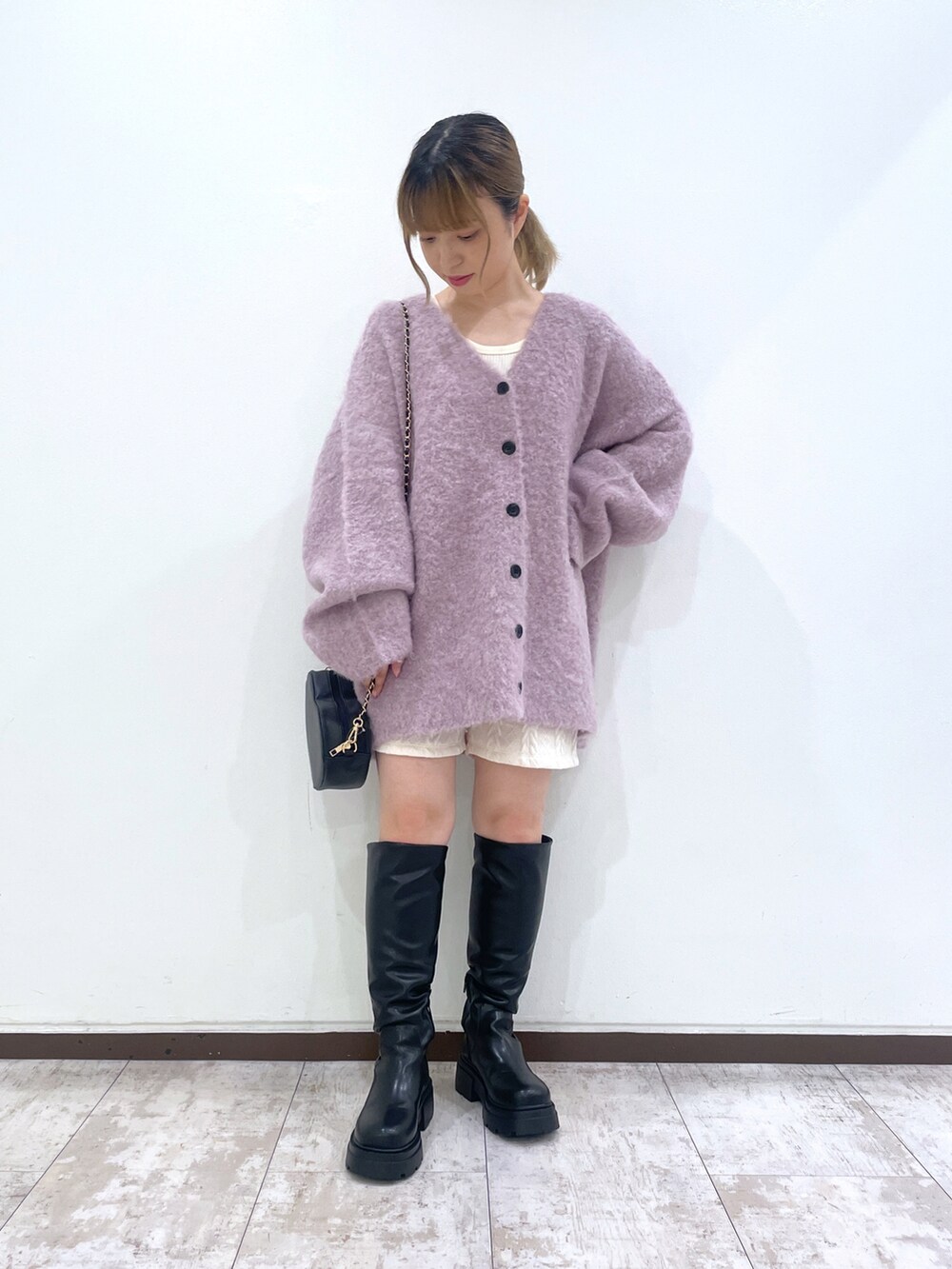 ブラック系のブーツ、ホワイト系のその他パンツ、パープル系のカーディガン/ボレロを着用したレディースの秋コーディネートの2枚目の写真