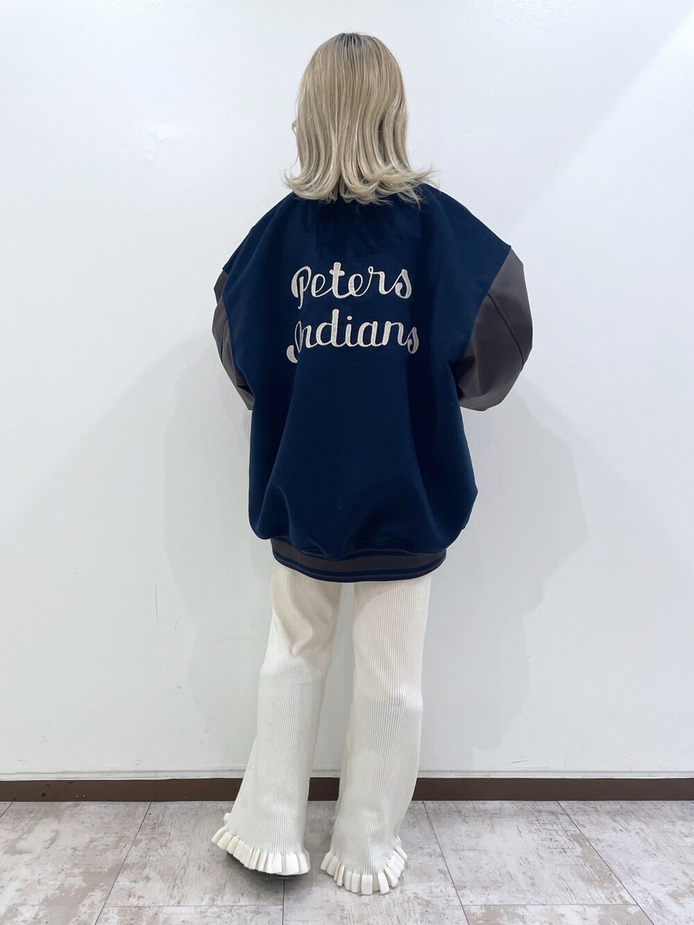 グレー系のニット/セーター、ブルー系のスタジャン、ホワイト系のその他パンツを着用したレディースの秋コーディネートの4枚目の写真