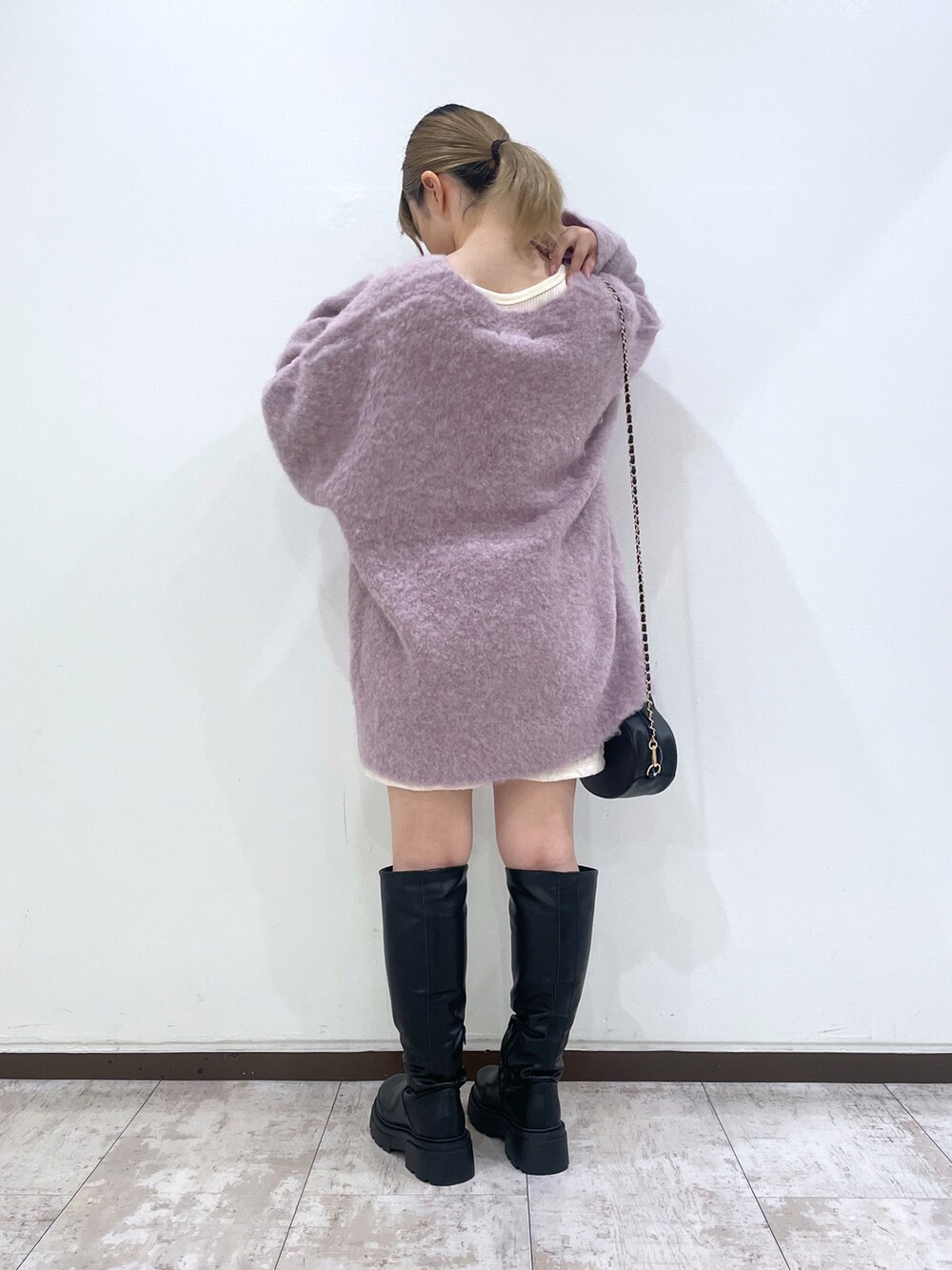 ブラック系のブーツ、ホワイト系のその他パンツ、パープル系のカーディガン/ボレロを着用したレディースの秋コーディネートの3枚目の写真