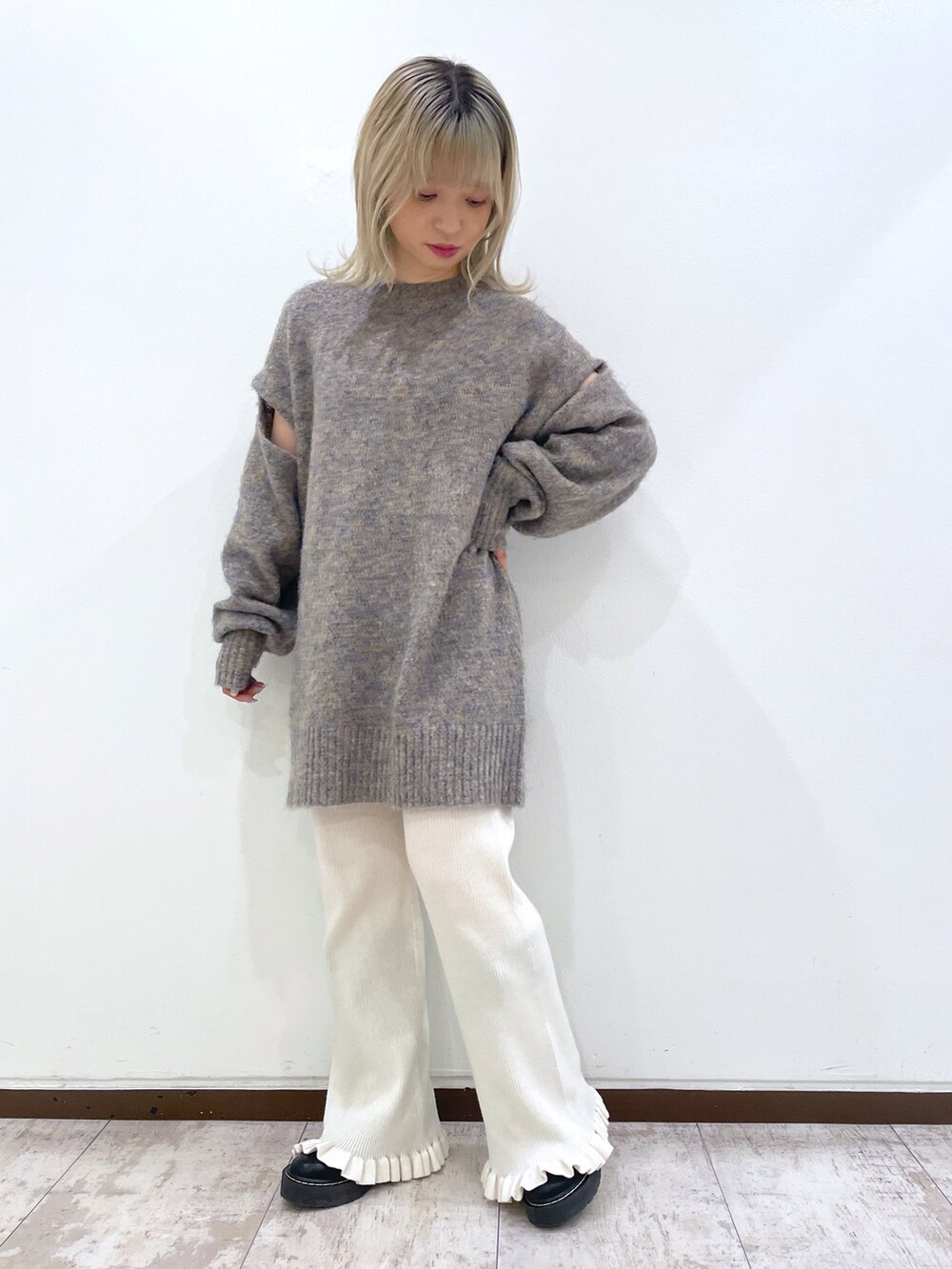 グレー系のニット/セーター、ブルー系のスタジャン、ホワイト系のその他パンツを着用したレディースの秋コーディネートの2枚目の写真