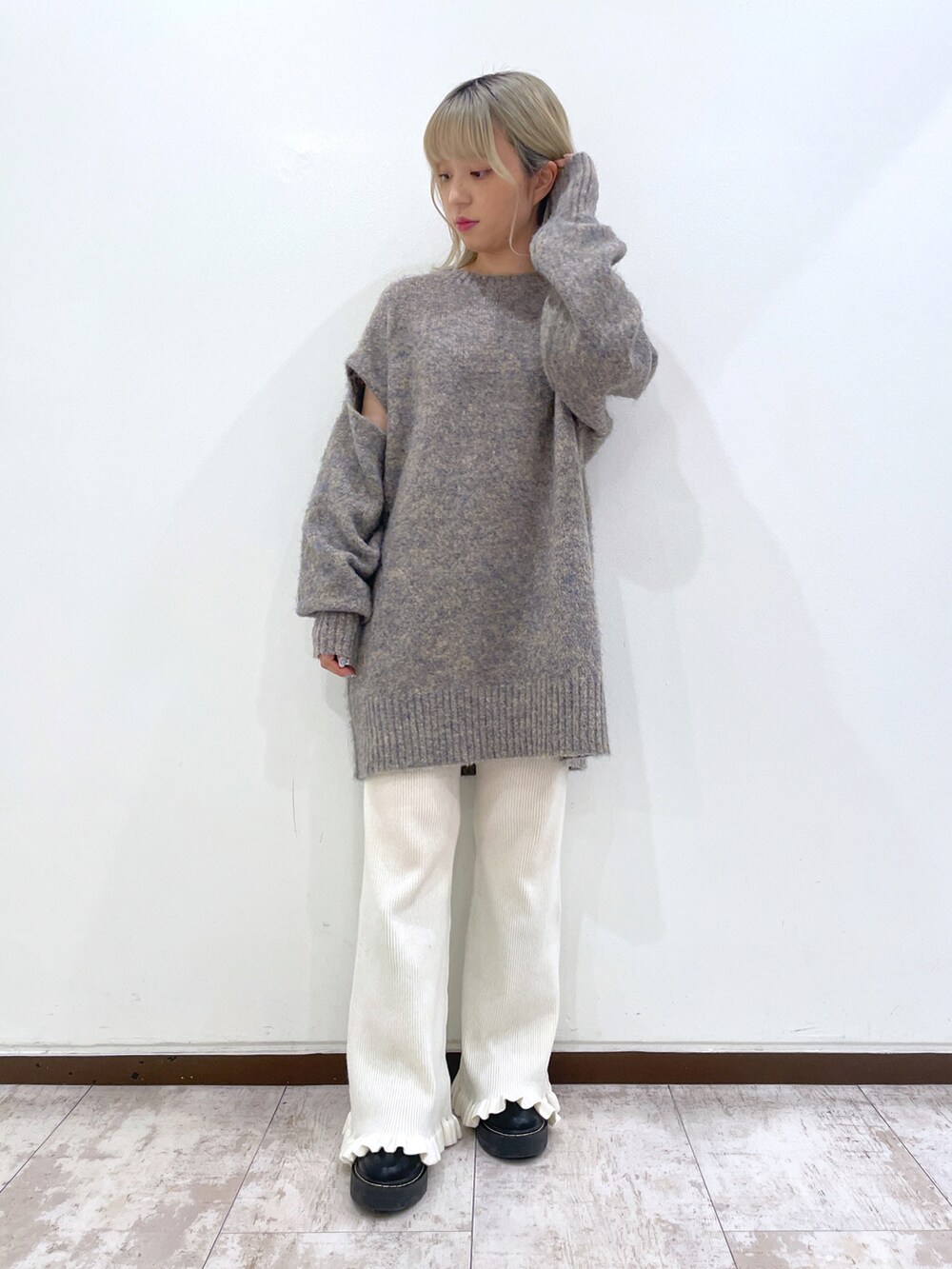 グレー系のニット/セーター、ブルー系のスタジャン、ホワイト系のその他パンツを着用したレディースの秋コーディネートの3枚目の写真