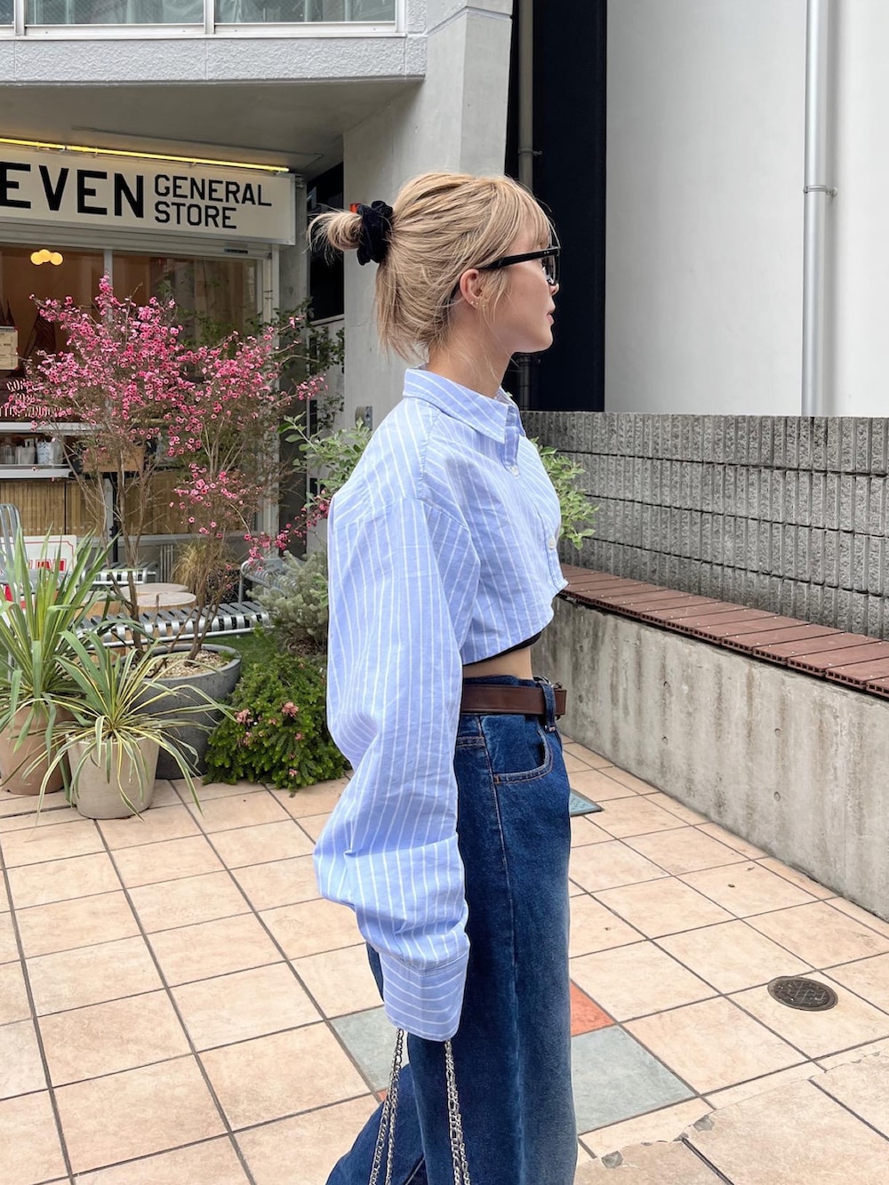 ブルー系のシャツ/ブラウス、シルバー系のショルダーバッグ、ブルー系のデニムパンツを着用したレディースの春コーディネートの2枚目の写真