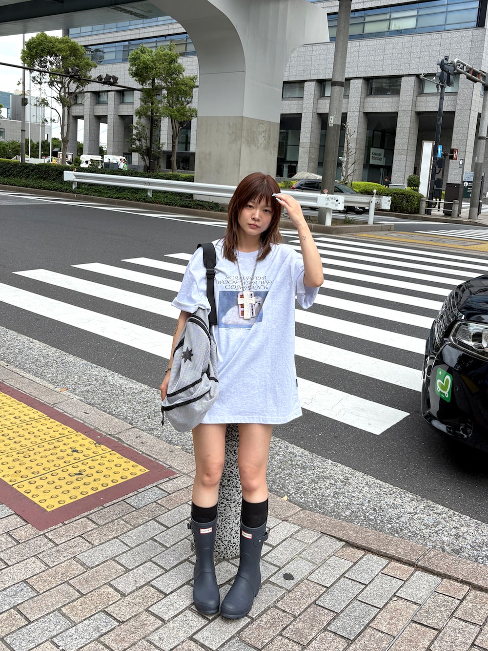 ブルー系のレインシューズ、グレー系のバックパック/リュック、グレー系のTシャツ/カットソーを着用したレディースの夏コーディネートの2枚目の写真