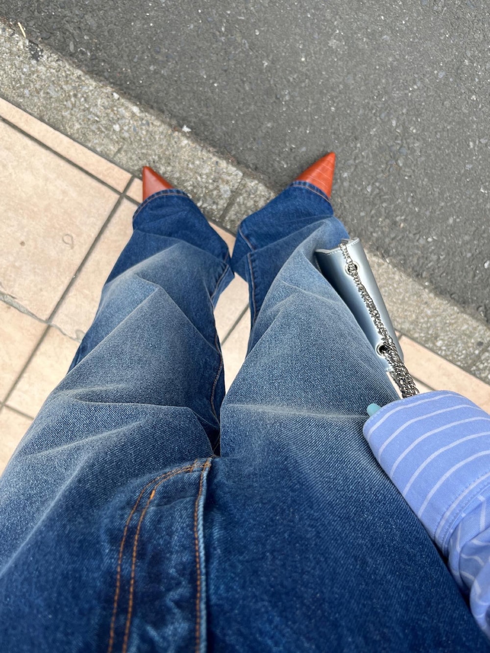 ブルー系のシャツ/ブラウス、シルバー系のショルダーバッグ、ブルー系のデニムパンツを着用したレディースの春コーディネートの3枚目の写真