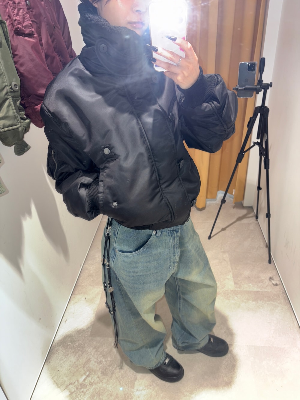 ブルー系のデニムパンツ、ブラック系のジャケット/アウター、ブラック系のスニーカーを着用したレディースの秋コーディネートの3枚目の写真