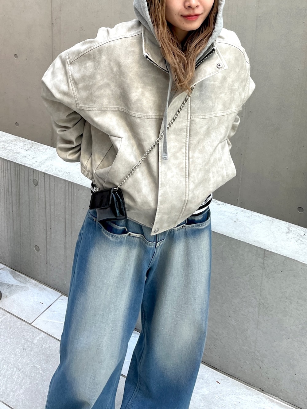 ブルー系のデニムパンツ、ホワイト系のブルゾンを着用したレディースの春コーディネートの2枚目の写真