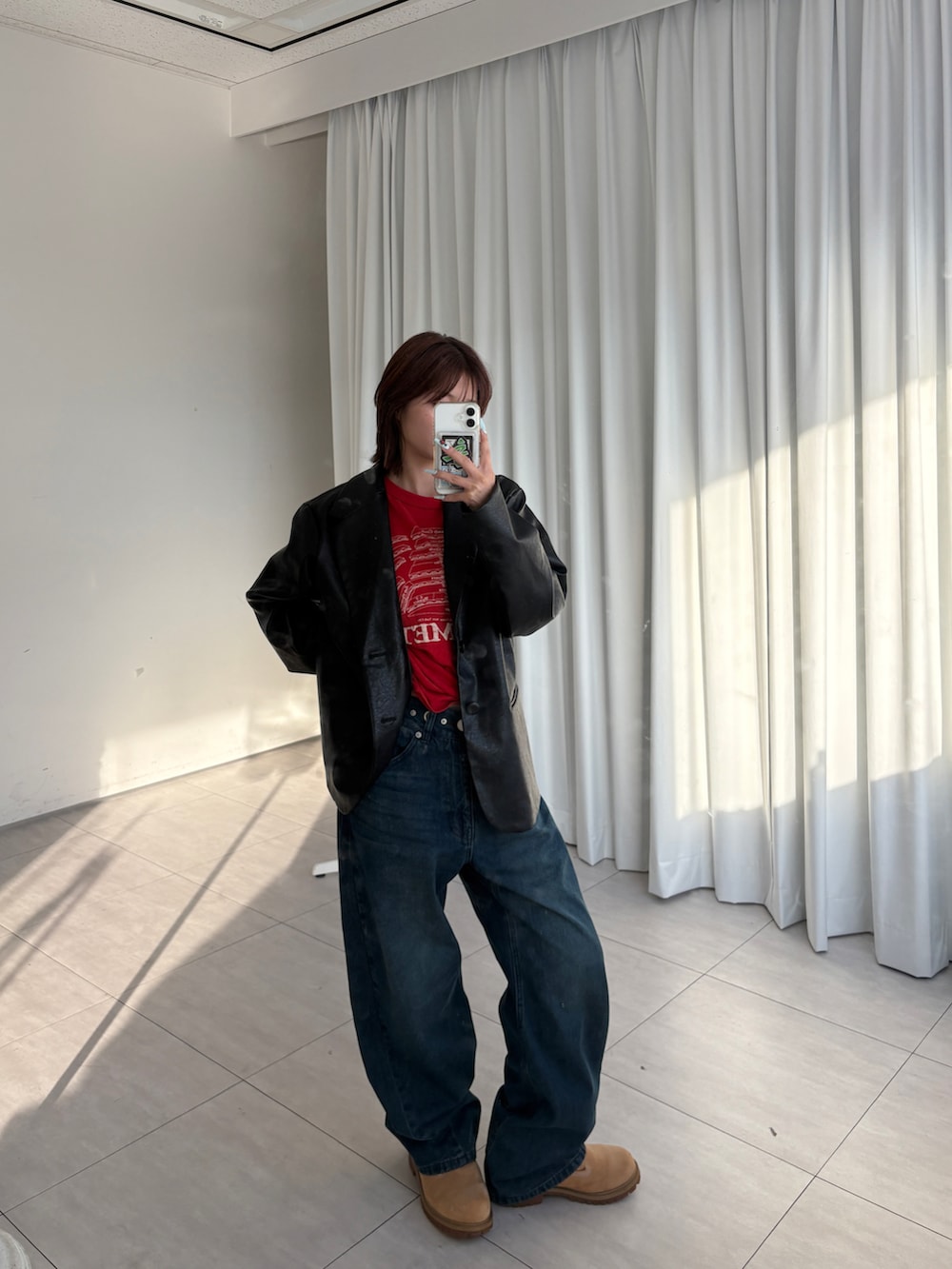 ブルー系のデニムパンツ、イエロー系のブーツ、ブラック系のテーラードジャケットを着用したレディースの夏コーディネートの2枚目の写真