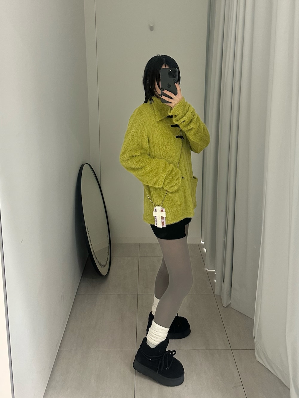 グリーン系のカーディガン/ボレロを着用したレディースの冬コーディネートの2枚目の写真