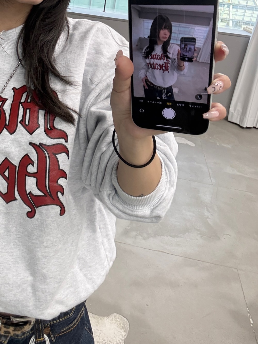 グレー系のスウェット、ブルー系のデニムパンツ、イエロー系のブーツを着用したレディースの春コーディネートの2枚目の写真