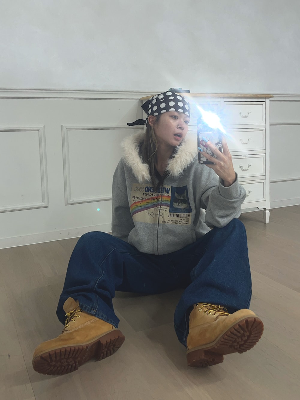 グレー系のパーカー、ブルー系のデニムパンツ、イエロー系のシューズを着用したレディースの冬コーディネートの2枚目の写真