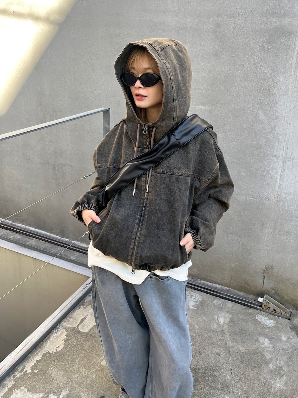 ブルー系のブルゾン、グレー系のTシャツ/カットソー、グレー系のデニムパンツを着用したレディースの冬コーディネートの2枚目の写真