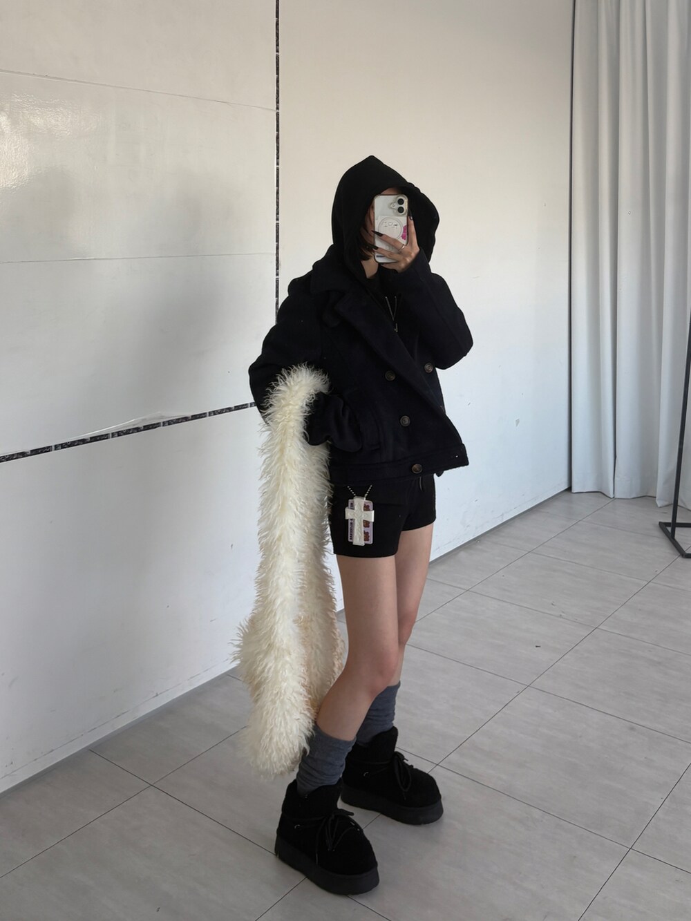 ブルー系のピーコート、ブラック系のパーカー、その他のショルダーバッグを着用したレディースの冬コーディネートの2枚目の写真