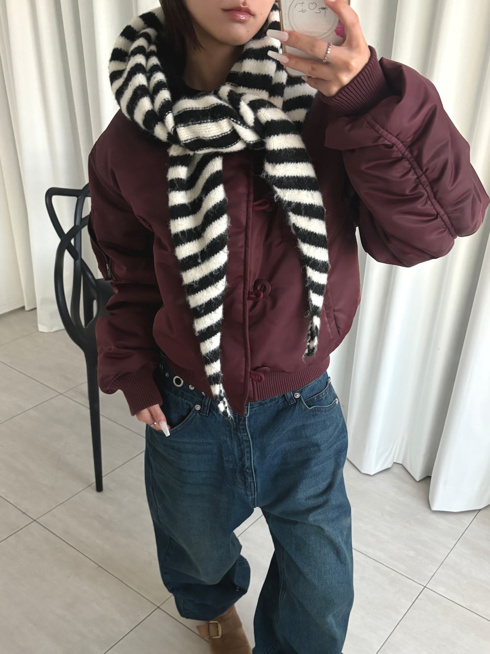 ブルー系のデニムパンツ、レッド系のミリタリージャケットを着用したレディースの秋コーディネートの2枚目の写真