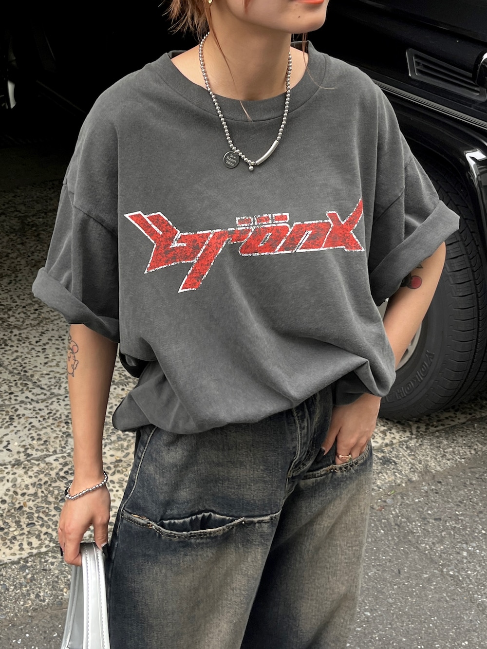 ブラック系のTシャツ/カットソー、ブルー系のデニムパンツ、ブラック系のブーツを着用したレディースの夏コーディネートの2枚目の写真