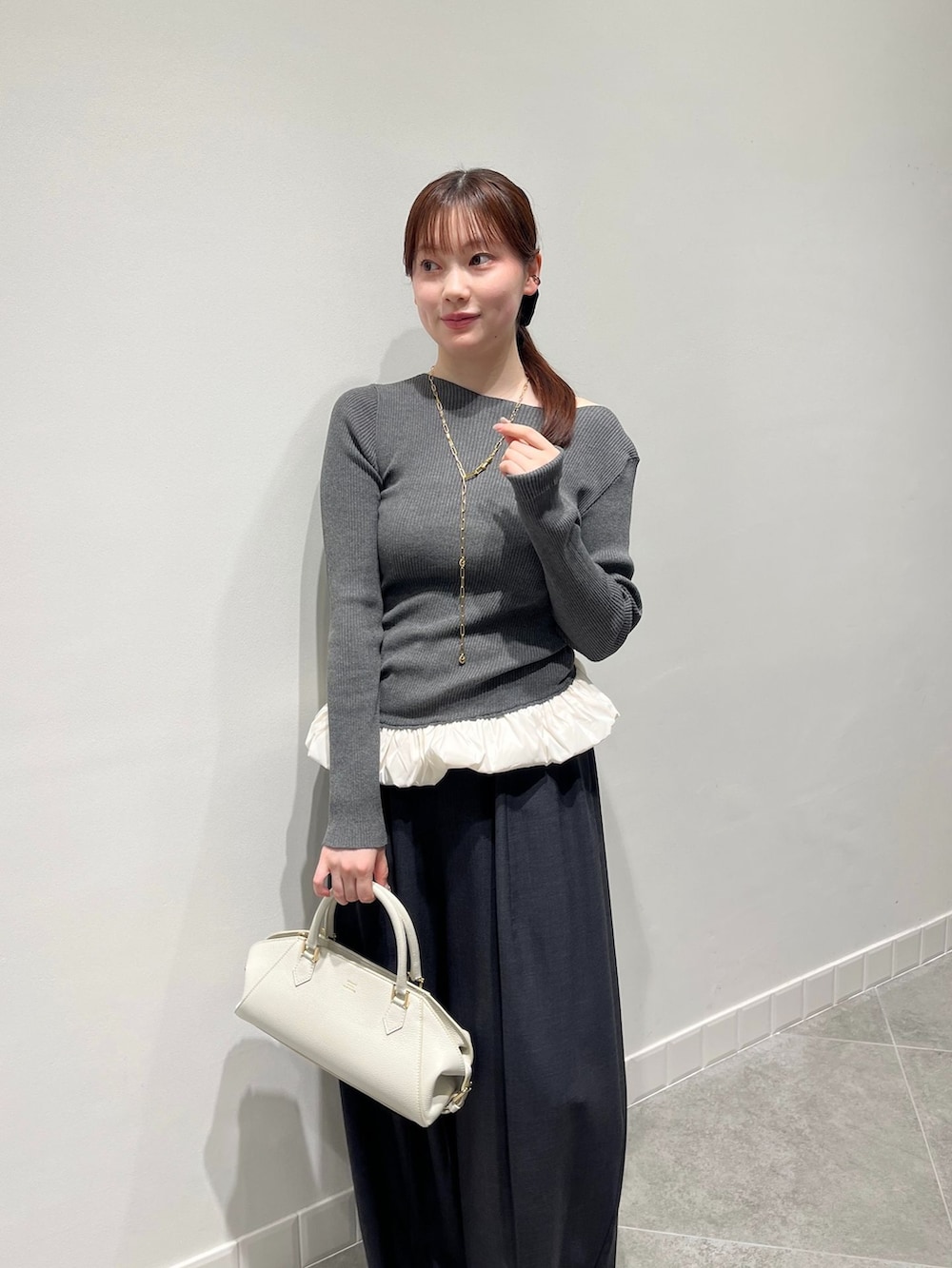 グレー系のその他パンツ、グレー系のニット/セーター、ホワイト系のボストンバッグを着用したレディースの秋コーディネートの3枚目の写真