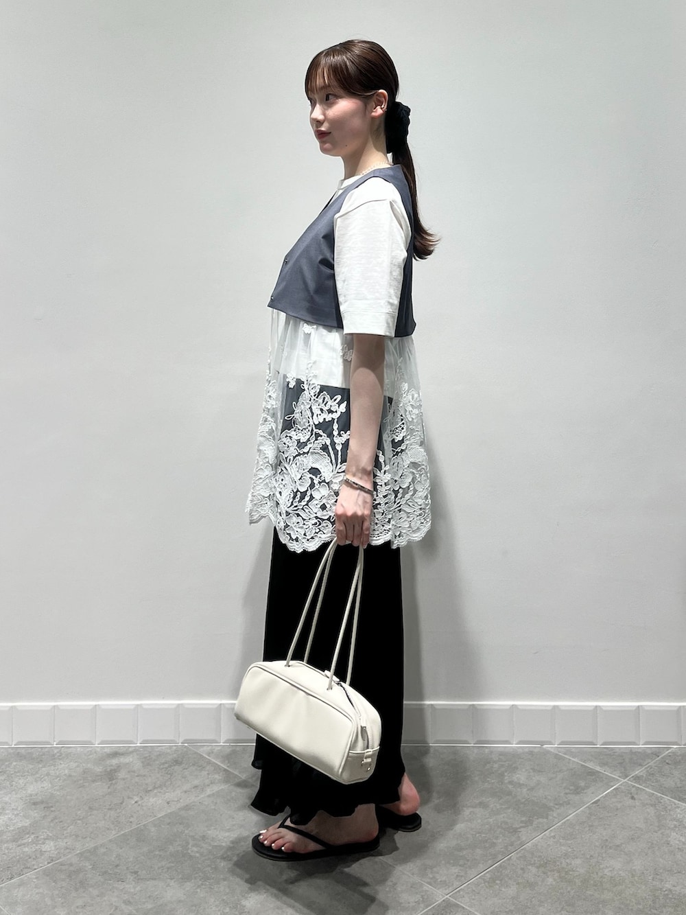 グレー系のベスト、ブラック系のスカート、ホワイト系のTシャツ/カットソーを着用したレディースの夏コーディネートの2枚目の写真