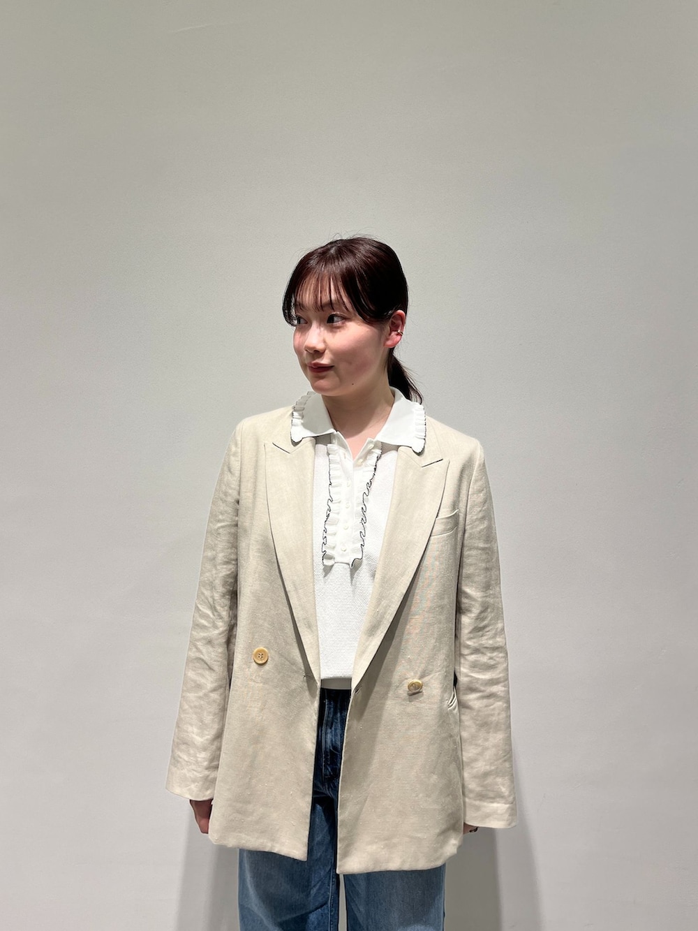 ベージュ系のテーラードジャケット、ブルー系のデニムパンツ、シルバー系のバレエシューズを着用したレディースの春コーディネートの5枚目の写真