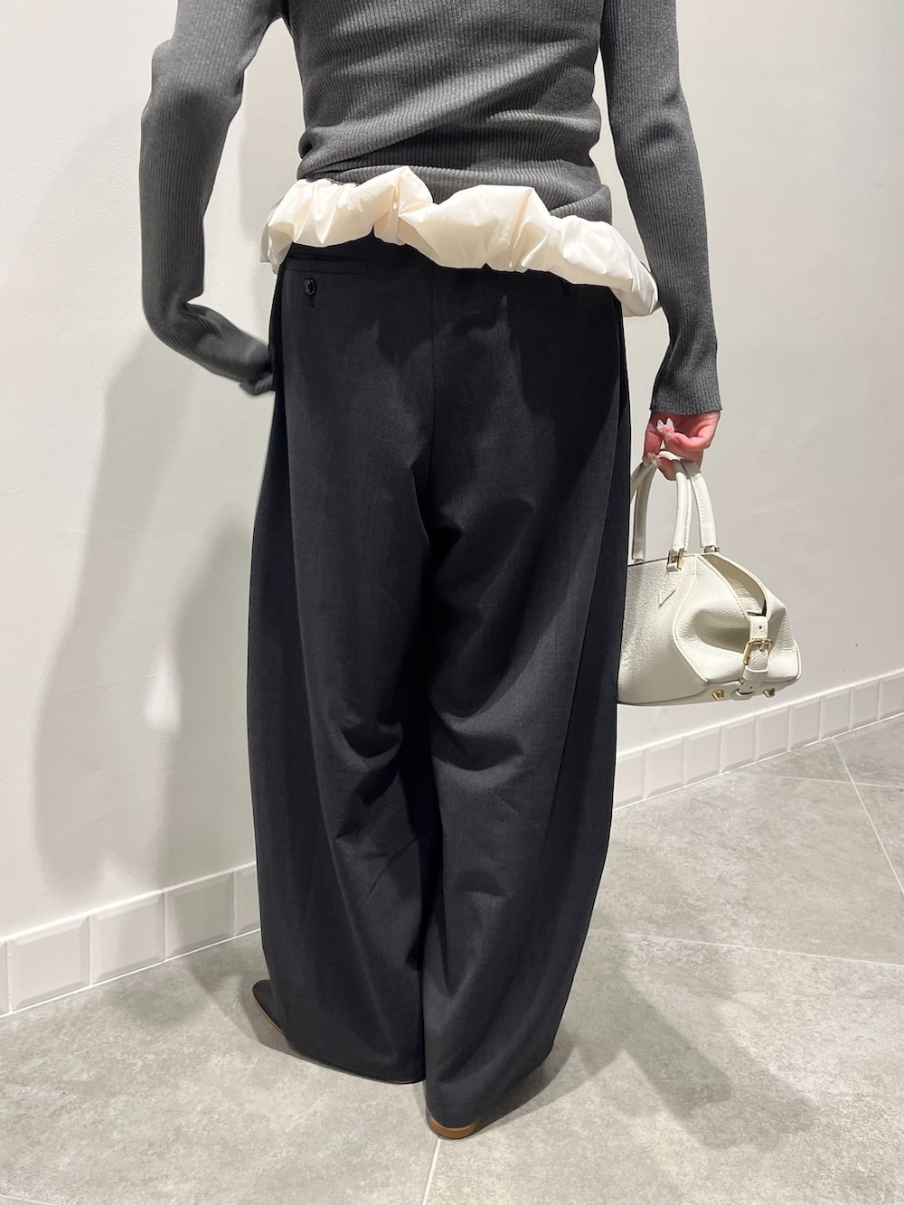 グレー系のその他パンツ、グレー系のニット/セーター、ホワイト系のボストンバッグを着用したレディースの秋コーディネートの6枚目の写真