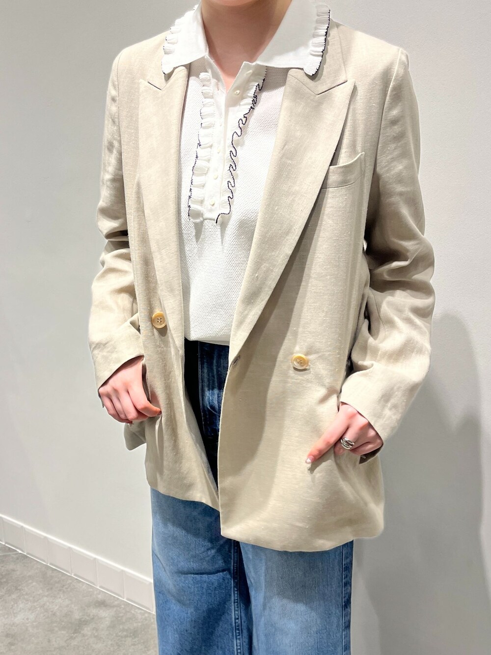 ベージュ系のテーラードジャケット、ブルー系のデニムパンツ、シルバー系のバレエシューズを着用したレディースの春コーディネートの6枚目の写真