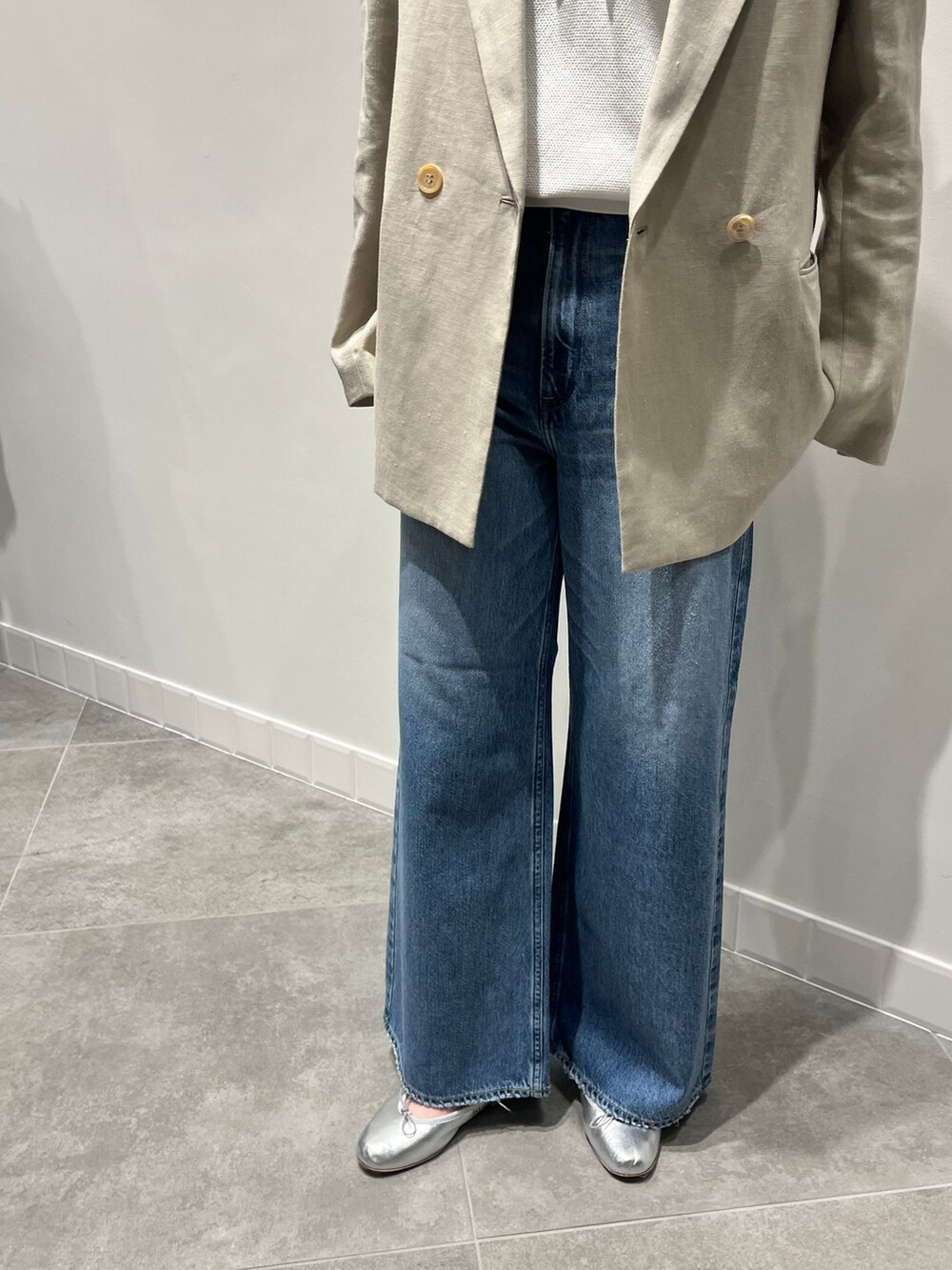 ベージュ系のテーラードジャケット、ブルー系のデニムパンツ、シルバー系のバレエシューズを着用したレディースの春コーディネートの7枚目の写真