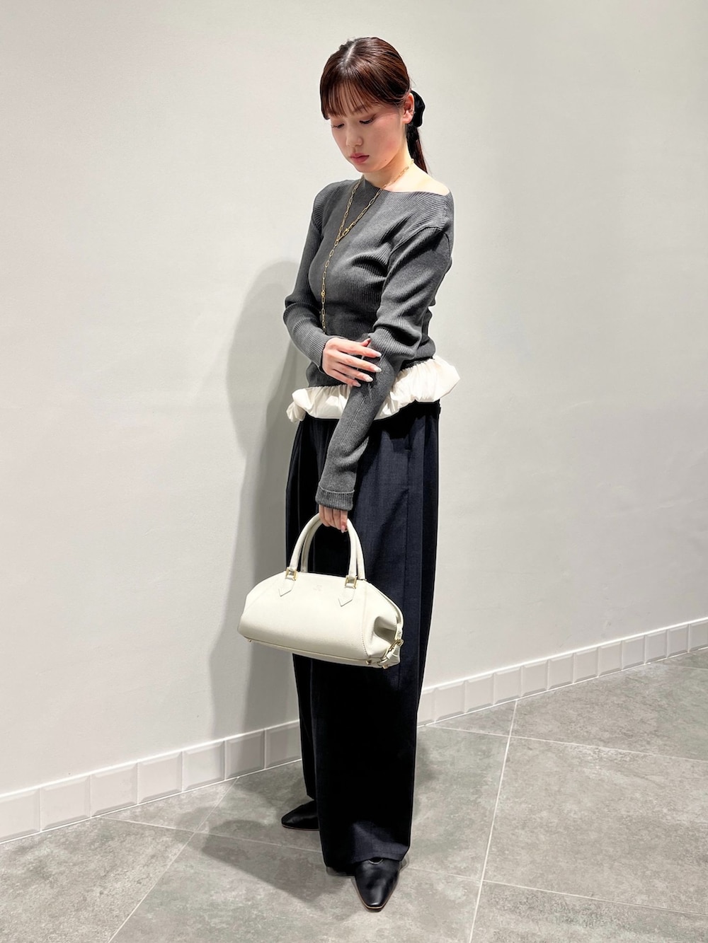 グレー系のその他パンツ、グレー系のニット/セーター、ホワイト系のボストンバッグを着用したレディースの秋コーディネートの2枚目の写真