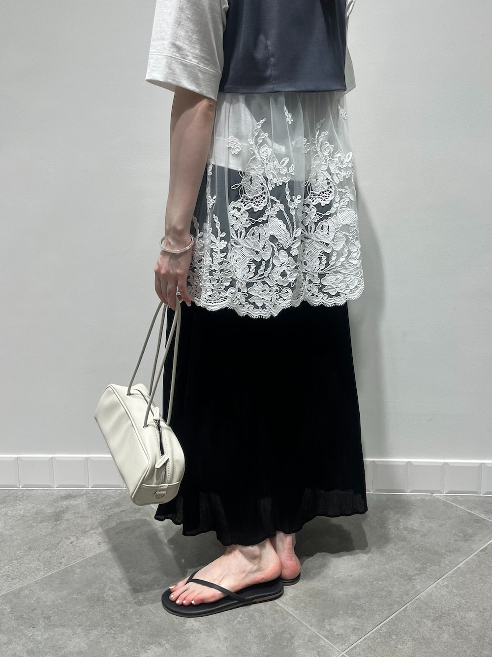 グレー系のベスト、ブラック系のスカート、ホワイト系のTシャツ/カットソーを着用したレディースの夏コーディネートの4枚目の写真