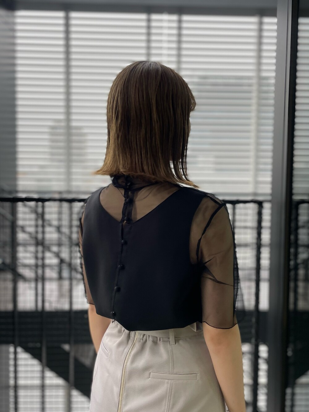 ホワイト系のスカート、ブラック系のシャツ/ブラウスを着用したレディースの春コーディネートの4枚目の写真