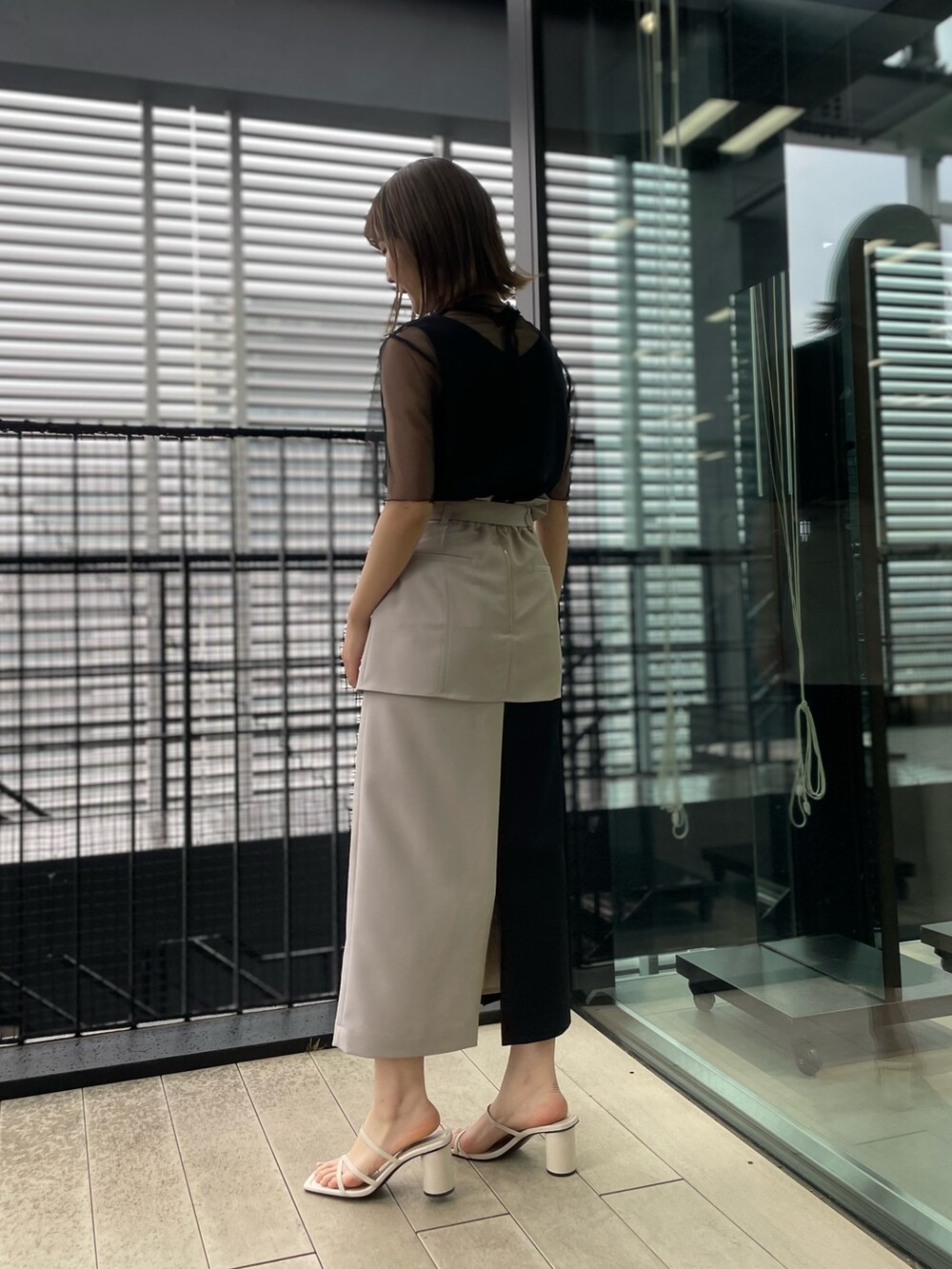 ホワイト系のスカート、ブラック系のシャツ/ブラウスを着用したレディースの春コーディネートの2枚目の写真