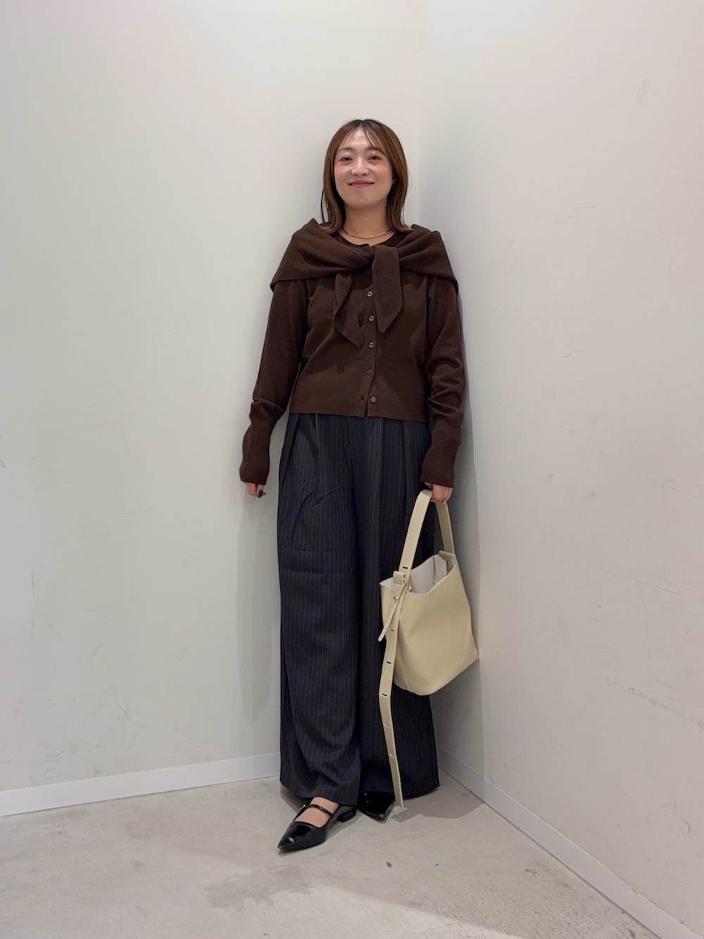 ブラウン系のカーディガン/ボレロ、グレー系のその他パンツ、ベージュ系のショルダーバッグを着用したレディースの秋コーディネートの7枚目の写真