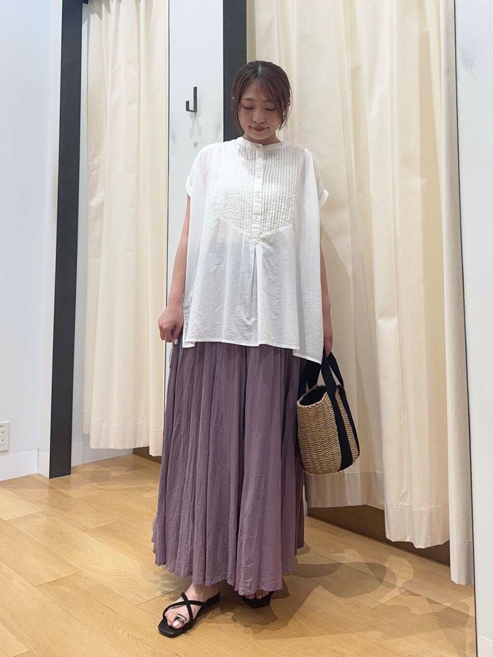ベージュ系のハンドバッグ、ホワイト系のTシャツ/カットソー、パープル系のスカートを着用したレディースの夏コーディネートの3枚目の写真
