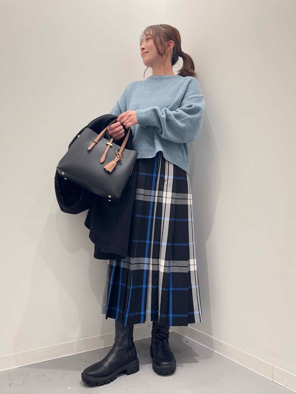 ブラック系のトートバッグ、ブラック系のその他アウター、ブラック系のブーツを着用したレディースの冬コーディネートの4枚目の写真