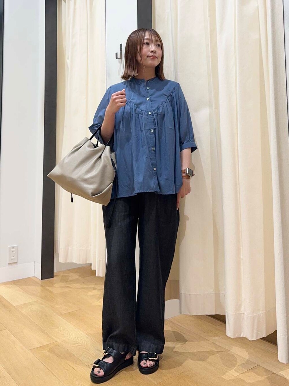ベージュ系のショルダーバッグ、ブラック系のサンダル、ブラック系のデニムパンツを着用したレディースの夏コーディネートの2枚目の写真