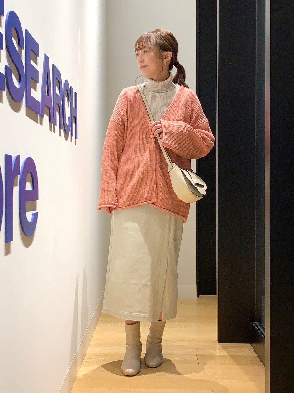ピンク系のカーディガン/ボレロ、グレー系のニット/セーター、ベージュ系のスカートを着用したレディースの冬コーディネートの4枚目の写真